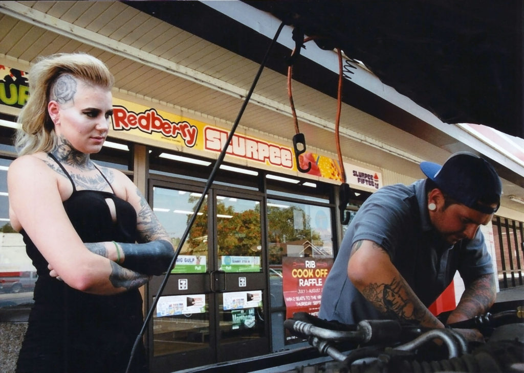 Frank Manfredonia, a TEC Equipment parts specialist helps Kayla Blackwell, artist at Invictus Tattoo Studio, in the parking lot of a 7-11 on Wells and Second streets. Photo by Mike Higdon